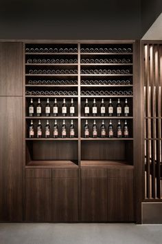 an empty wine cellar with wooden shelves and bottles on the wall in front of it