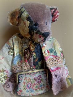 a teddy bear with a purse sitting on top of it's lapel cover