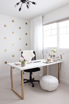 a white desk with gold polka dots on the wall