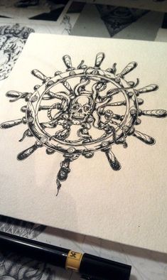 a pen and ink drawing of a skull in a wheel with skulls on the side