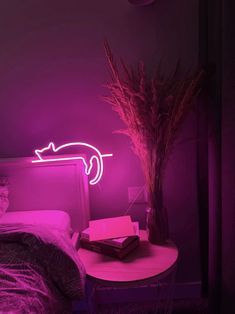 a pink light is shining on a bed in a room with a table and chair