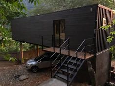 a car is parked in front of a house with stairs leading up to the roof