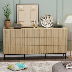 a living room scene with focus on the sideboard and lamp in the foreground