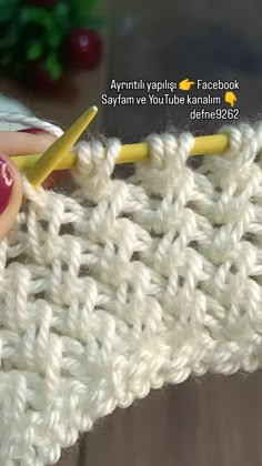 the crochet stitch is being worked on by someone using a yellow knitting needle