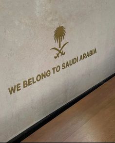 we belong to saudi written on the side of a wall with palm trees and swords