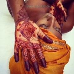 a woman's hands with henna tattoos on them