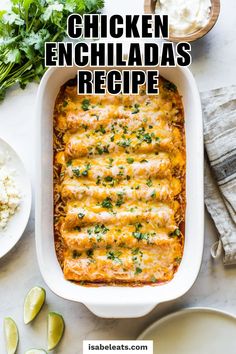 chicken enchiladas recipe in a white casserole dish with limes on the side