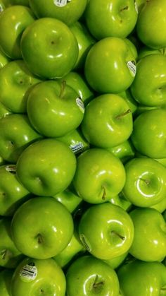 many green apples stacked on top of each other