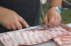 a person cutting up some meat on top of a table