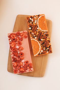 two slices of fruit and nuts are on a cutting board next to an orange slice