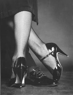 a woman's legs with fishnet stockings and high heels in black and white