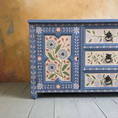 an ornate painted dresser with drawers and knobs