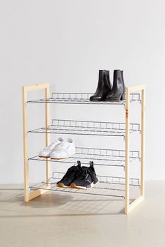 three pairs of shoes are sitting on top of a rack that holds four pairs of shoes