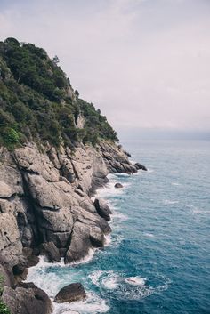 an ocean cliff with waves crashing against the rocks