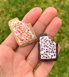 two miniature pieces of bread with sprinkles on them in the palm of someone's hand