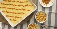 a table topped with bowls filled with food next to two white plates and spoons