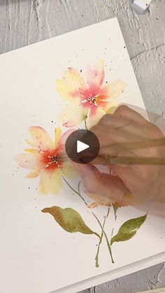 someone is painting flowers with watercolors on paper