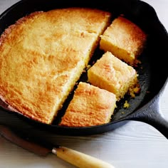 a cast iron skillet filled with cornbreads on top of a wooden table