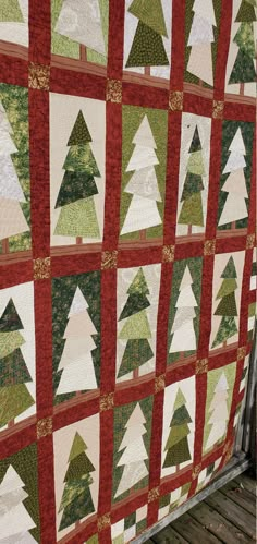 a red and green quilt with trees on it