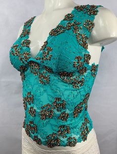 "Hand decorated sleeveless lace top in Green and Copper Gold color combination on floral patterned lace with shiny sequins and beads. Perfect for any occasion. 1. Available in 4 sizes: S, M, L, and XL. 2. Has three rows of hooks-eye position at the back which makes it easy to fit perfectly in your body. 3. Made from stretch lace which helps you easily adjust to your body size. 4. Individually hand beaded. 5. Light in weight and comfortable to wear. 6. Has cotton lining in the inner bust area to Green And Copper, Crop Top Sleeveless, Gold Color Combination, Lace Sleeveless Top, Sequin Crop Top, Long Crop Top, Womens Blouses, Top Sleeveless, Stretch Lace