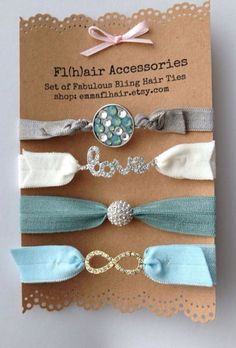 four hair ties in different colors and designs on a brown card with white doily