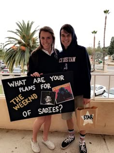 two people holding up signs and standing next to each other