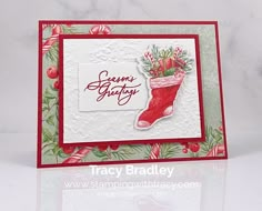 a handmade christmas card with a stocking boot and holly wreaths on it