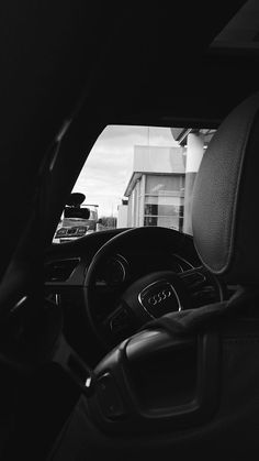 the interior of a car with steering wheel, dashboard and center console in black and white