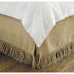 a close up view of a bed with fringed linens on the bottom and sides