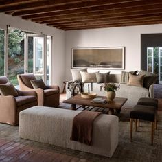 a living room filled with lots of furniture next to a wooden floor covered in windows