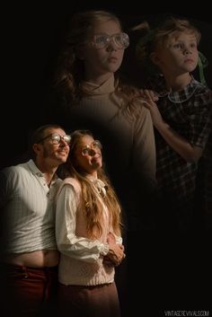 two children and an adult are standing in front of a black background with the image of three people