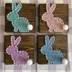 four wooden coasters with crocheted rabbits on them