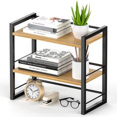 a book shelf with books and a clock on the top, next to a potted plant