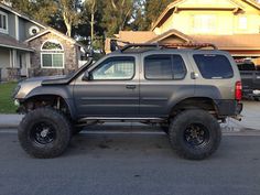 a grey four - door suv parked in front of a house