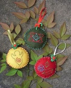 three ornaments are sitting on the ground next to some leaves