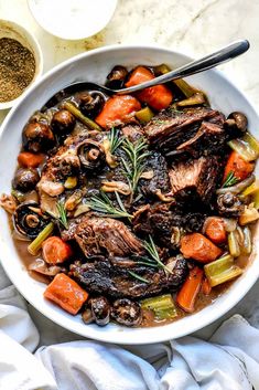 a white bowl filled with meat and vegetables