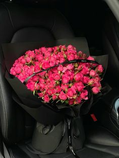 a bouquet of pink roses in the back seat of a car, ready to be delivered