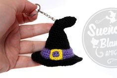 a crocheted witch hat keychain is being held by someone's hand