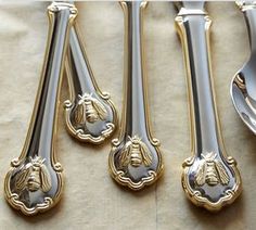 four silver and gold spoons sitting next to each other on top of a table