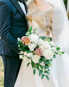 the bride and groom are holding their dog