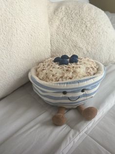 a bowl filled with cereal sitting on top of a bed