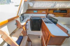 the interior of a sailboat with sink, stove and counter space on it's side