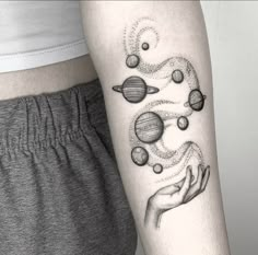 a woman's arm with planets on it