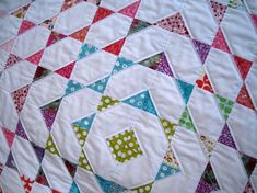 a quilted table topper with many different colors and patterns on it's surface