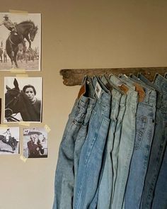 jeans hanging up against a wall with pictures on it