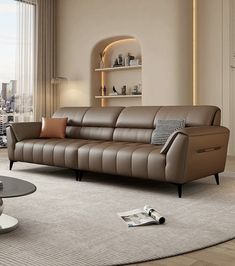 a living room with a couch, coffee table and large window overlooking the cityscape