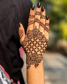 a woman's hand with henna tattoos on it