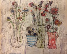 three vases filled with flowers sitting next to each other on a tablecloth covered surface