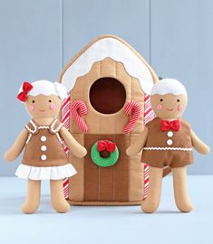 two gingerbread man and woman standing in front of a house made out of cardboard