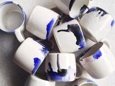 several white and blue cups are stacked on top of each other with one cup in the middle